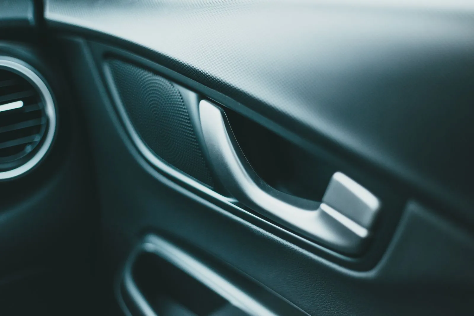 Closeup of closed door and speaker near shiny door handle of modern car in daylight